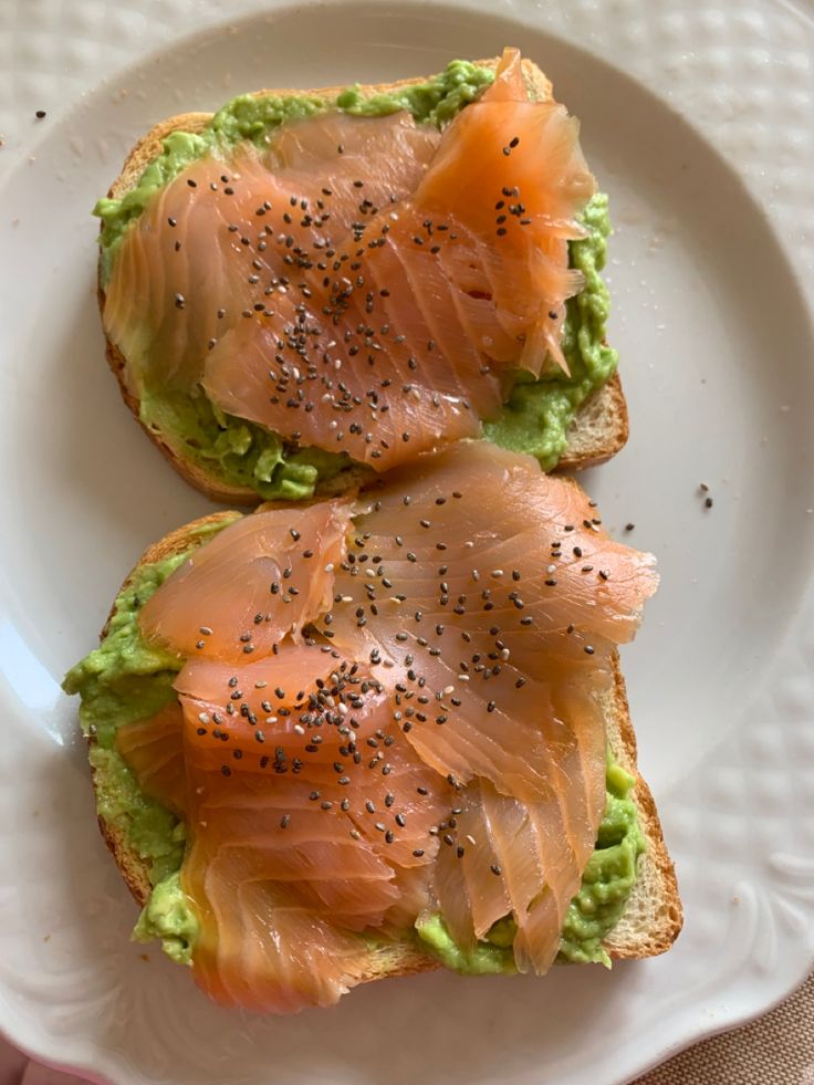 two pieces of bread topped with salmon and avocado