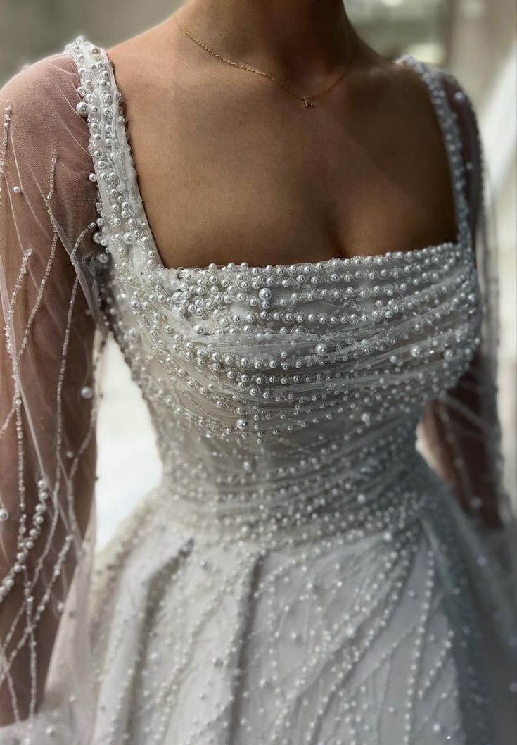 the back of a woman's dress with pearls on it