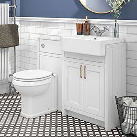 a white toilet sitting next to a sink in a bathroom under a mirror and towel rack