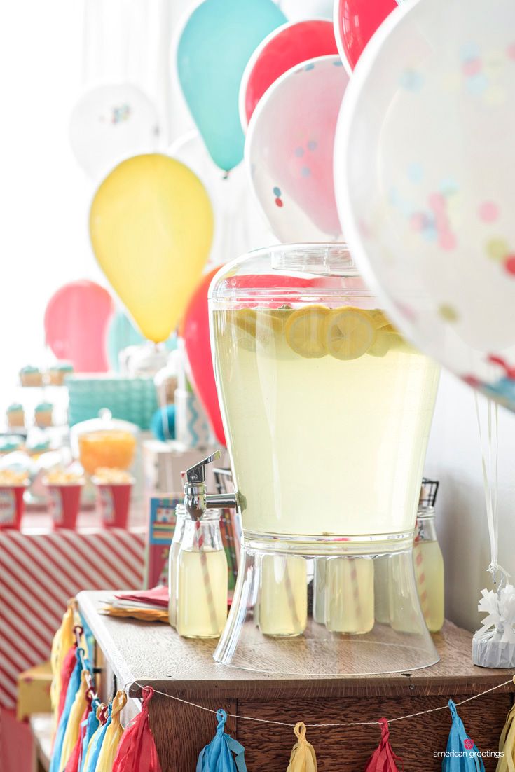 a table topped with balloons and bottles filled with liquid