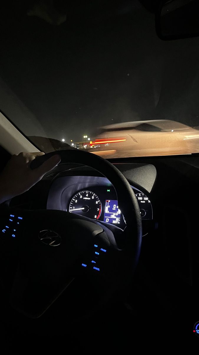 the interior of a car at night with lights on and dash lights visible in the background