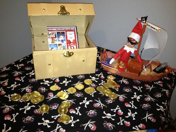 a toy pirate ship and some gold coins on a bed with a santa clause hat