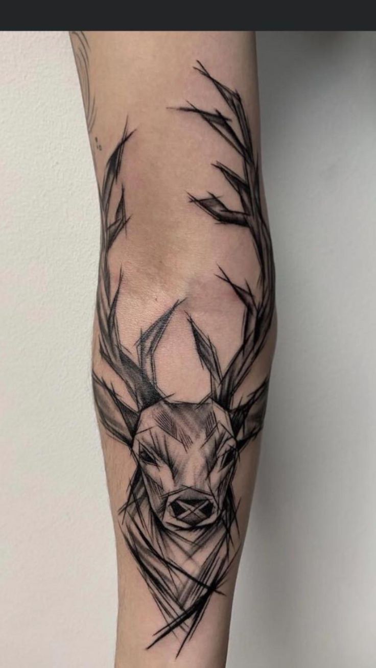 a black and white tattoo of a deer's head