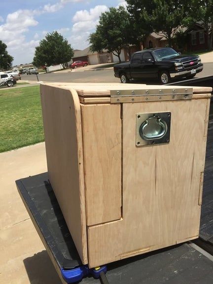 a wooden cabinet sitting on the back of a truck