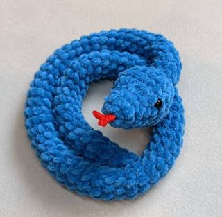 a blue knitted snake with a red nose