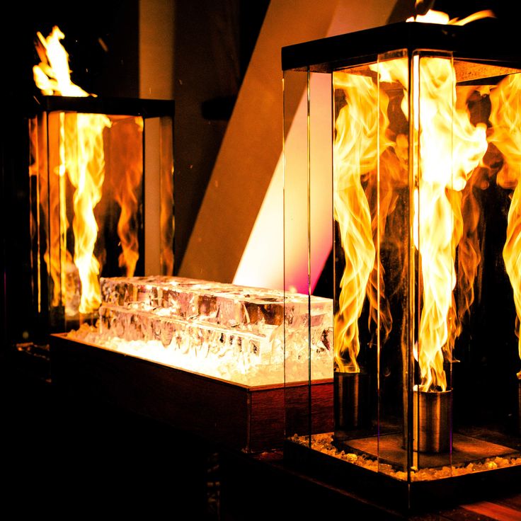 two glass cases with flames inside of them