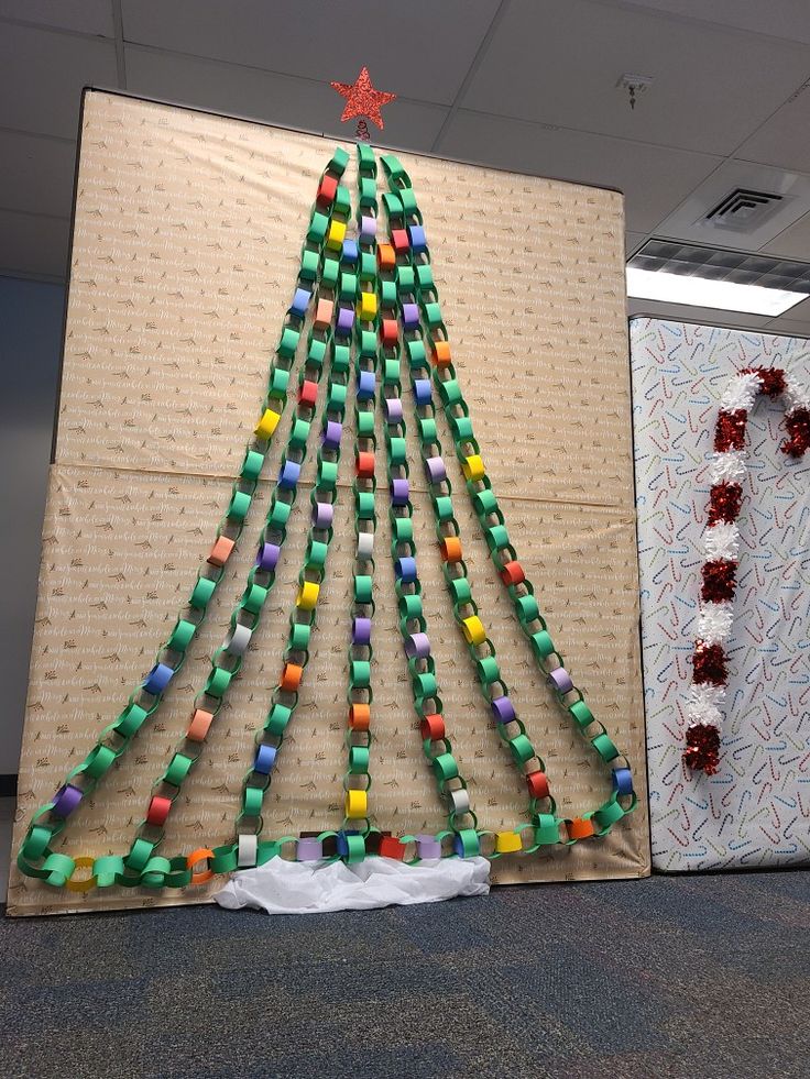 a christmas tree made out of legos is displayed in front of a cardboard wall