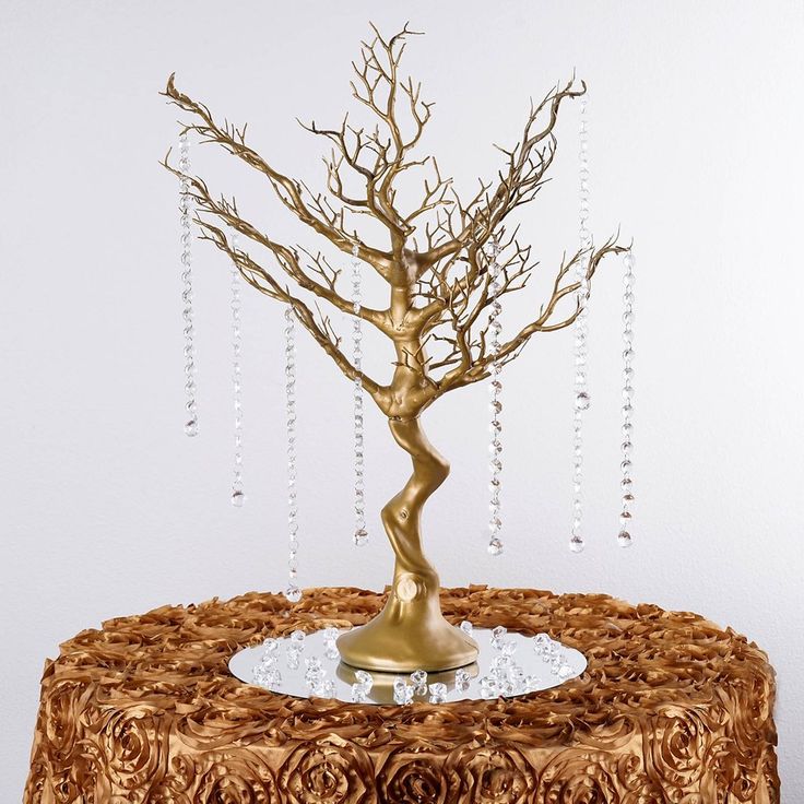 a cake with a gold tree on top and beads hanging from it's sides