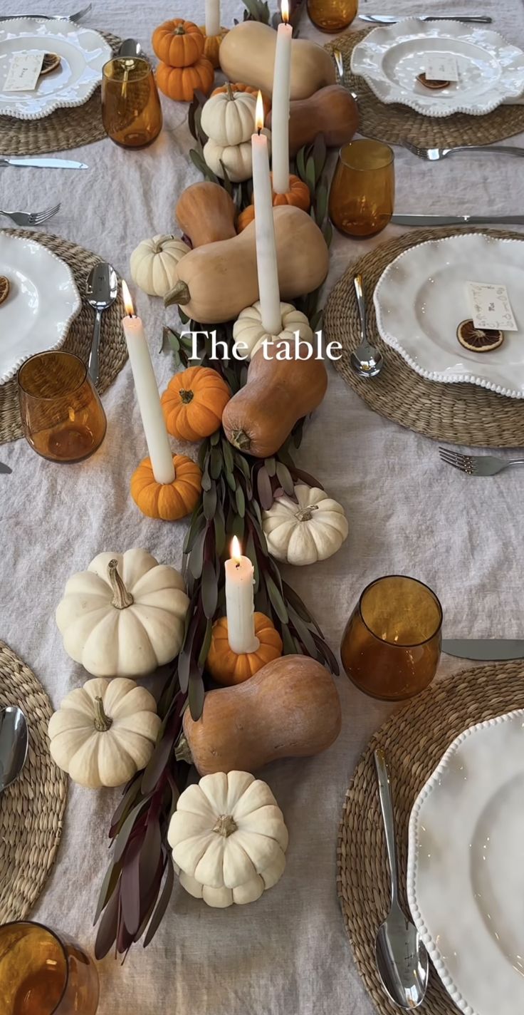 the table is set with candles and pumpkins