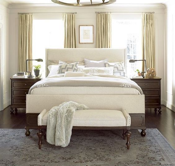 a bedroom with a large bed, dresser and chair in it's center area