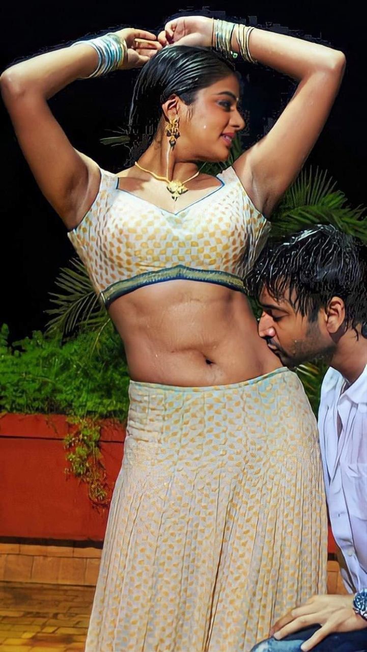 a man standing next to a woman on top of a wooden floor in front of a potted plant