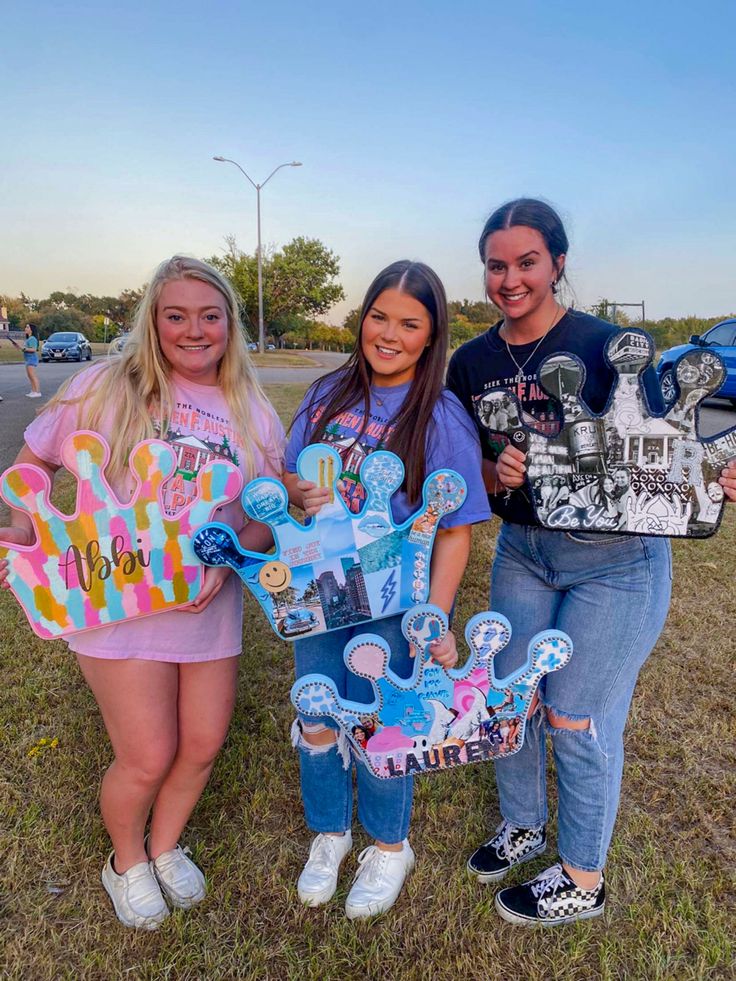 three girls are standing in the grass with skateboards and one is holding a sign that says happy birthday