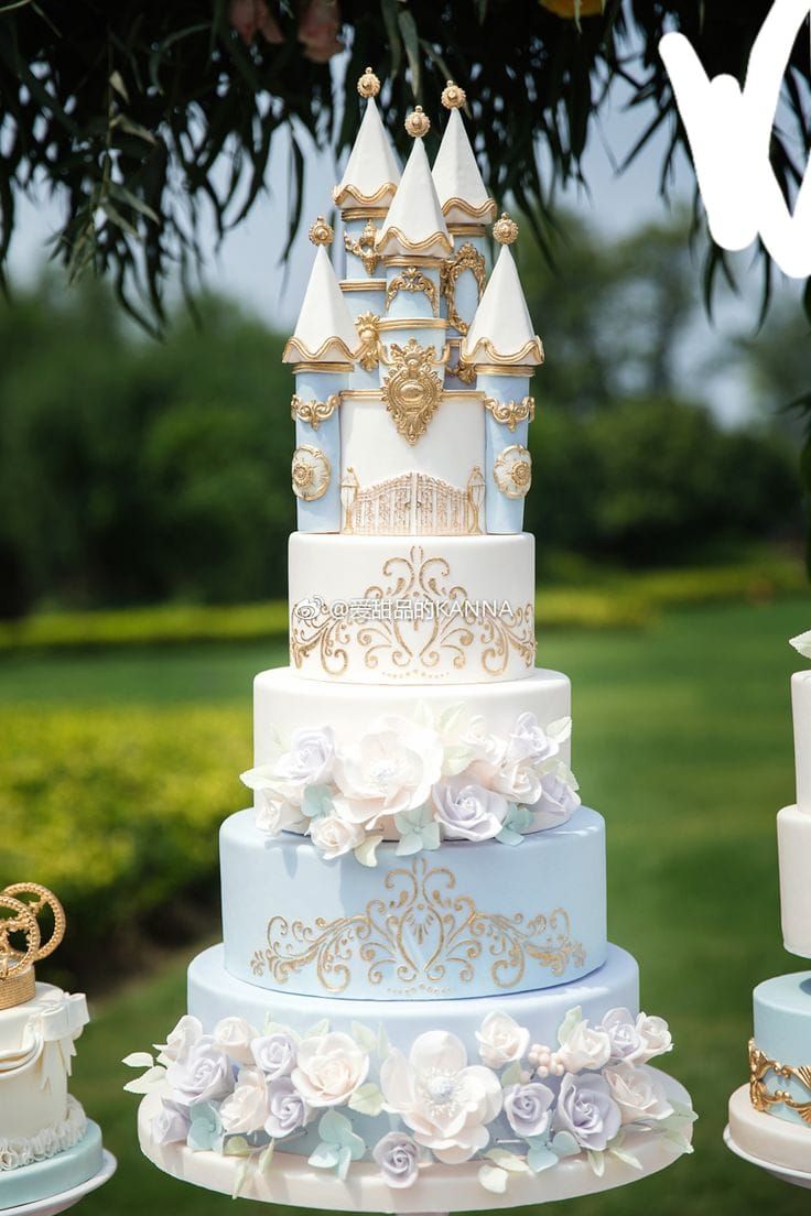 a multi layer cake sitting on top of a table covered in white and blue frosting