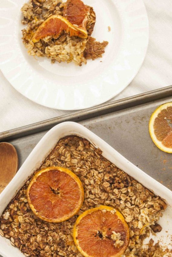 two plates with orange slices and oatmeal on them