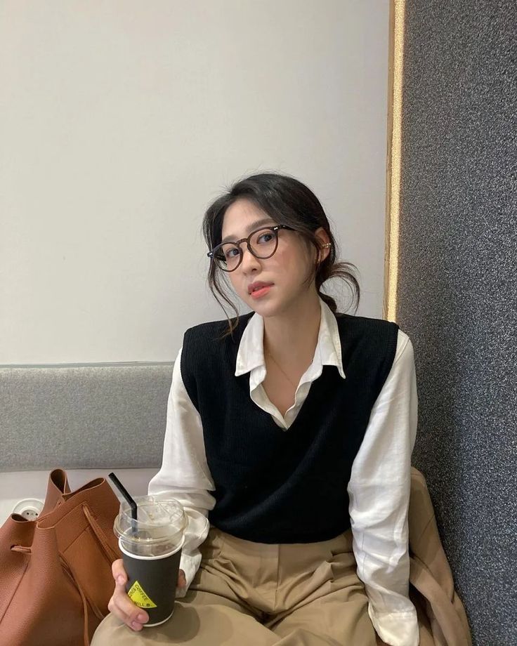 a woman sitting on the floor holding a coffee cup