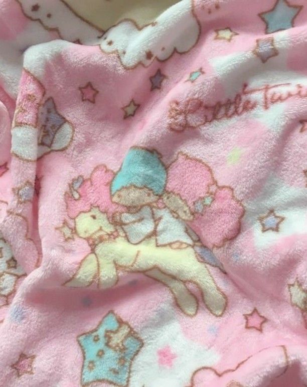 a pink hello kitty blanket laying on top of a bed