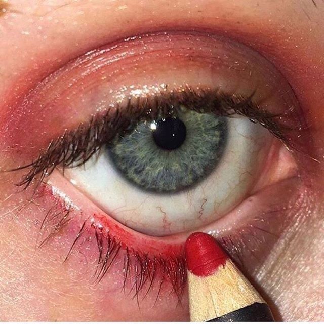 a woman's eye with a pencil in the middle of her left eye and an eraser on top of it