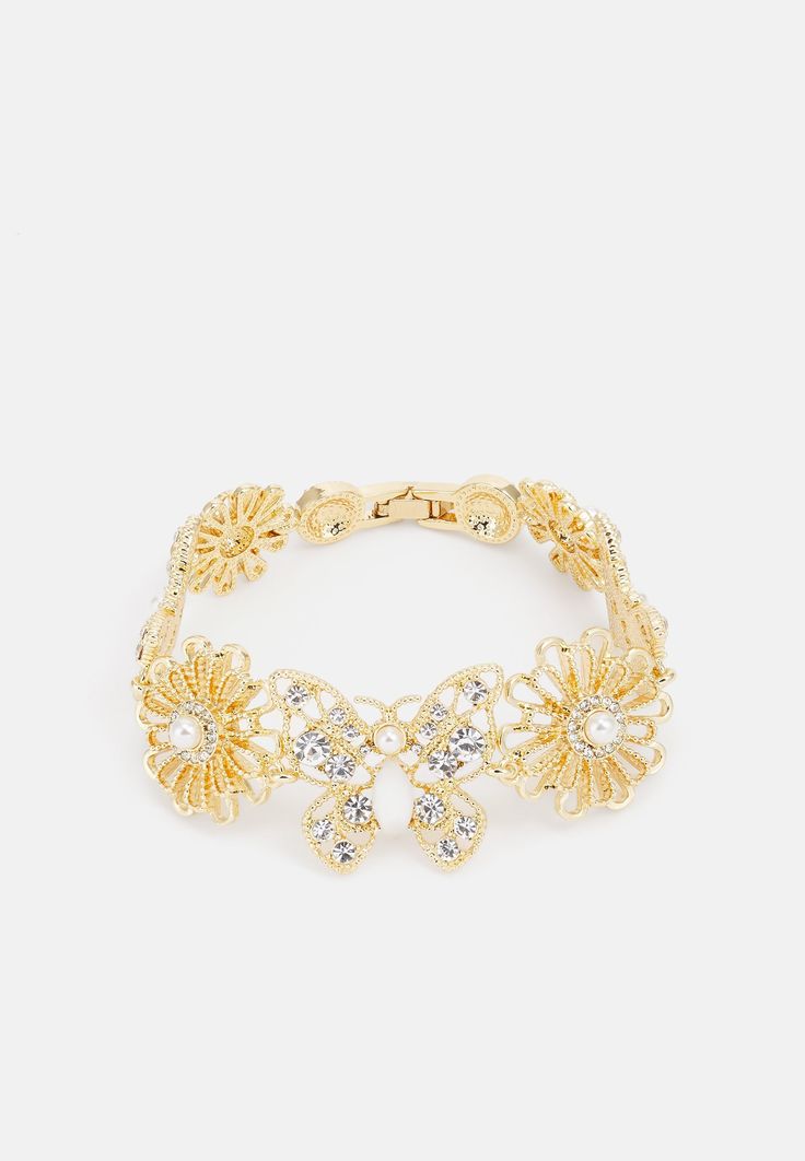 Discover the "Marquise" golden floral bracelet, a piece of jewelry that embodies elegance and glamour. This refined bracelet is crafted from zinc, acrylic and glass, and adorned with a shiny polished finish. Decorative crystals and imitation pearls add a touch of luxury, perfect for enhancing anyone. With a circumference of 7.5 inches and a width of 1 inch, this bracelet provides a comfortable fit while making a bold style statement. The delicate floral pattern is ideal for those who provide nat Luxury Elegant Bracelets With Polished Beads, Luxury Statement Bracelets With Shiny Finish, Luxury Statement Bracelet With Shiny Finish, Luxury Shiny Finish Bracelet, Luxury Shiny Finish Bracelets, Luxury Glamorous Crystal Bracelets, Decorative Crystals, Shiny Rings, Sophisticated Jewelry