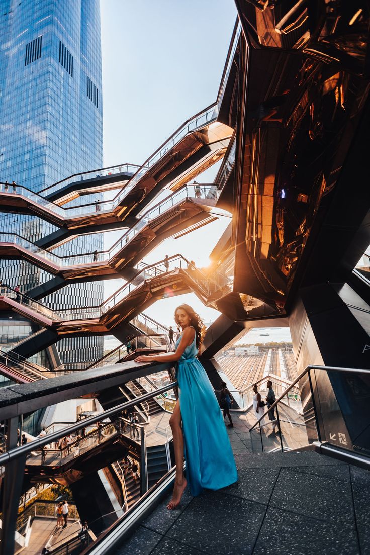 a woman in a blue dress standing on stairs