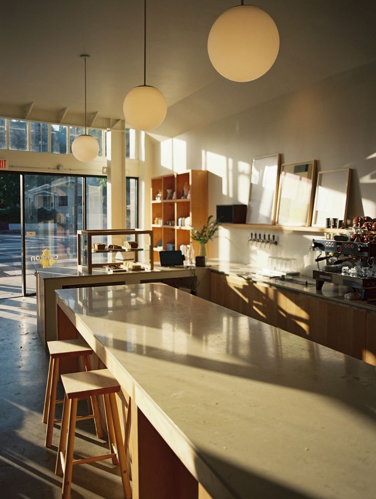 an open kitchen with lots of counter space and stools in front of the bar