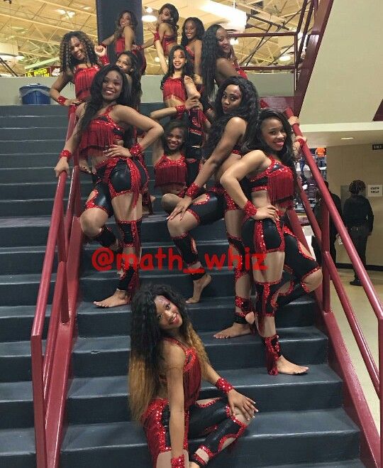 a group of women dressed in red and black posing on some stairs