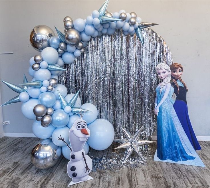 the balloon arch has been decorated with frozen princess and snowman balloons, which are hanging from it's sides