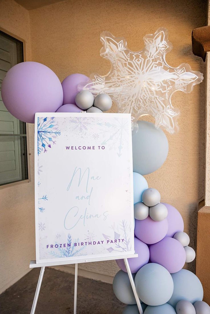 a welcome sign and balloon arch for a frozen birthday party