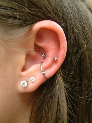 a close up of a person's ear with three piercings