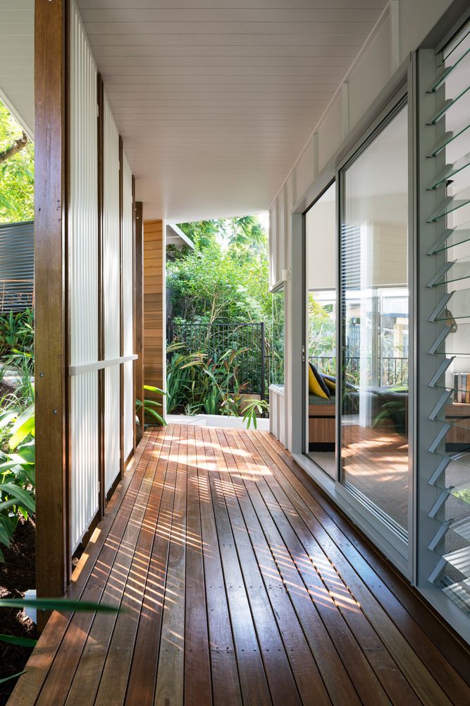 a long wooden porch with sliding glass doors leading to the back yard and deck area