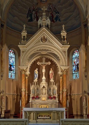 the inside of a church with pews and stained glass windows on either side of the alter