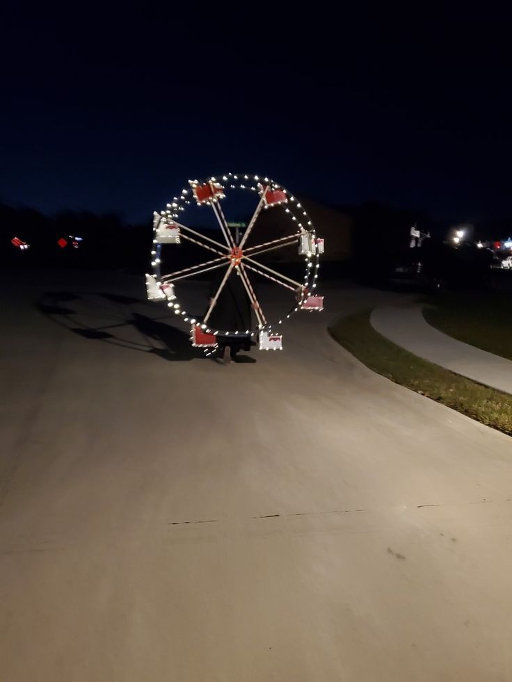 a large ferris wheel sitting on the side of a road