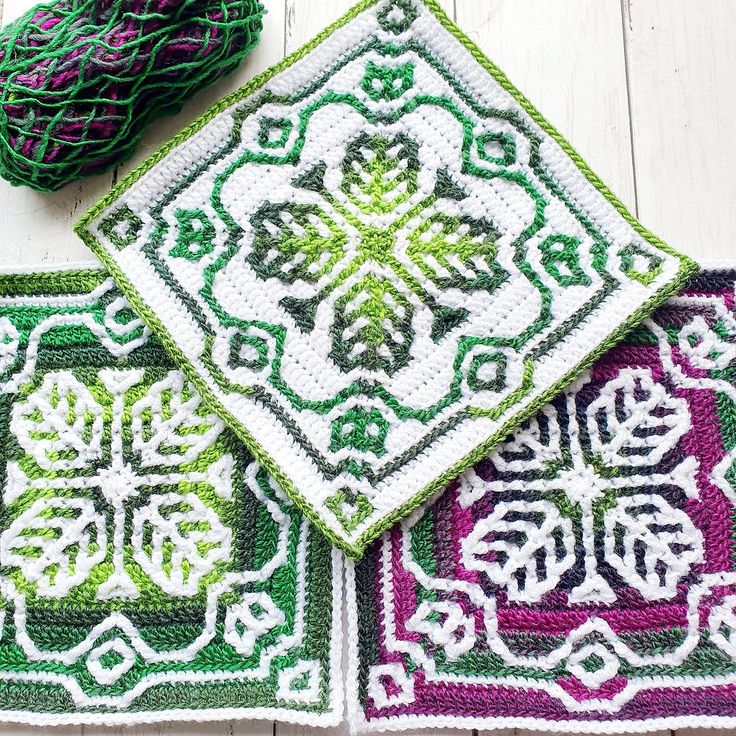 three crocheted placemats with green, purple and white designs on them