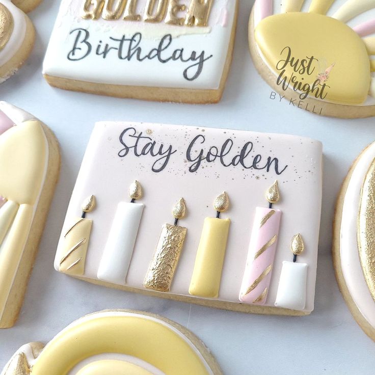 decorated cookies with candles and congratulations messages are displayed on a white tablecloth that says golden, stay golden