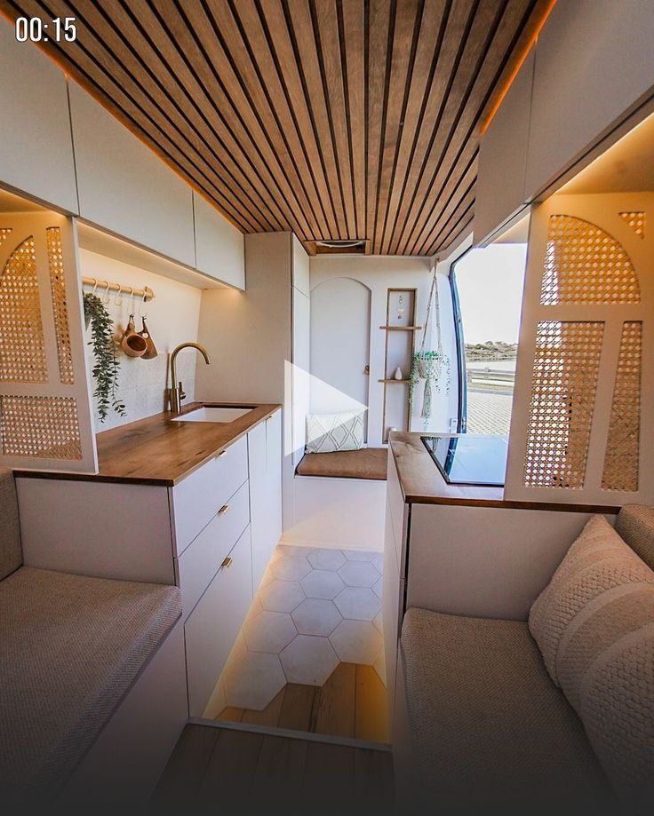 the interior of a tiny house with white walls and wood ceilinging, along with an open kitchen area