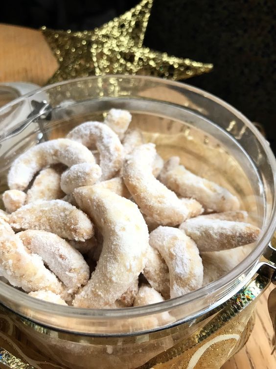 a glass bowl filled with powdered donuts on top of a wooden table next to a star