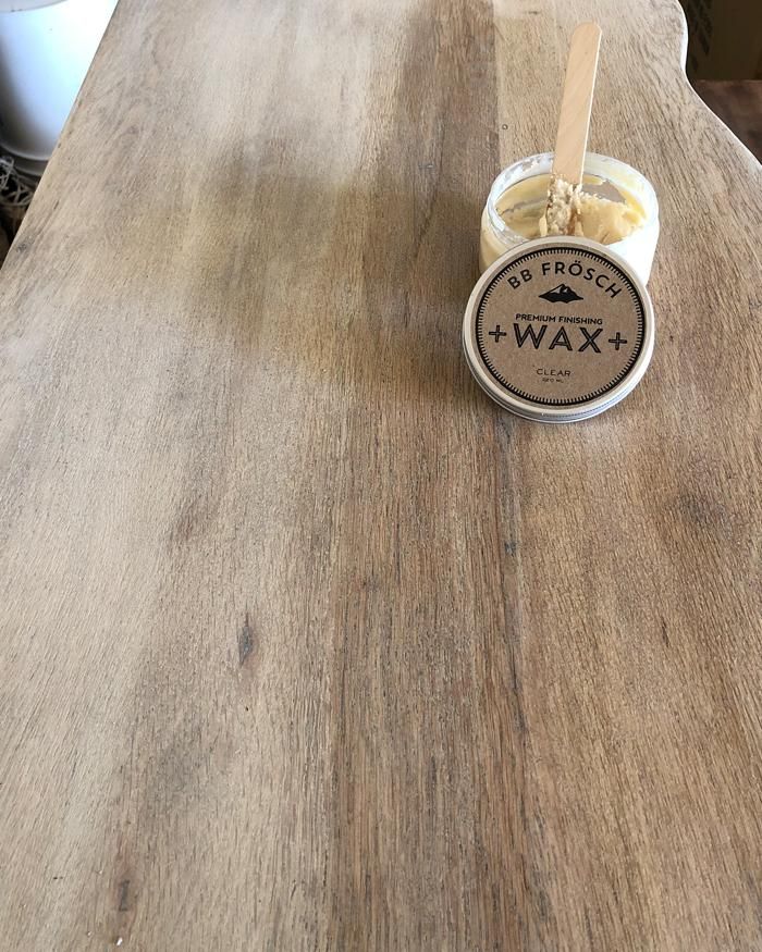 a wooden table with a jar of wax on it and a spoon sticking out of it