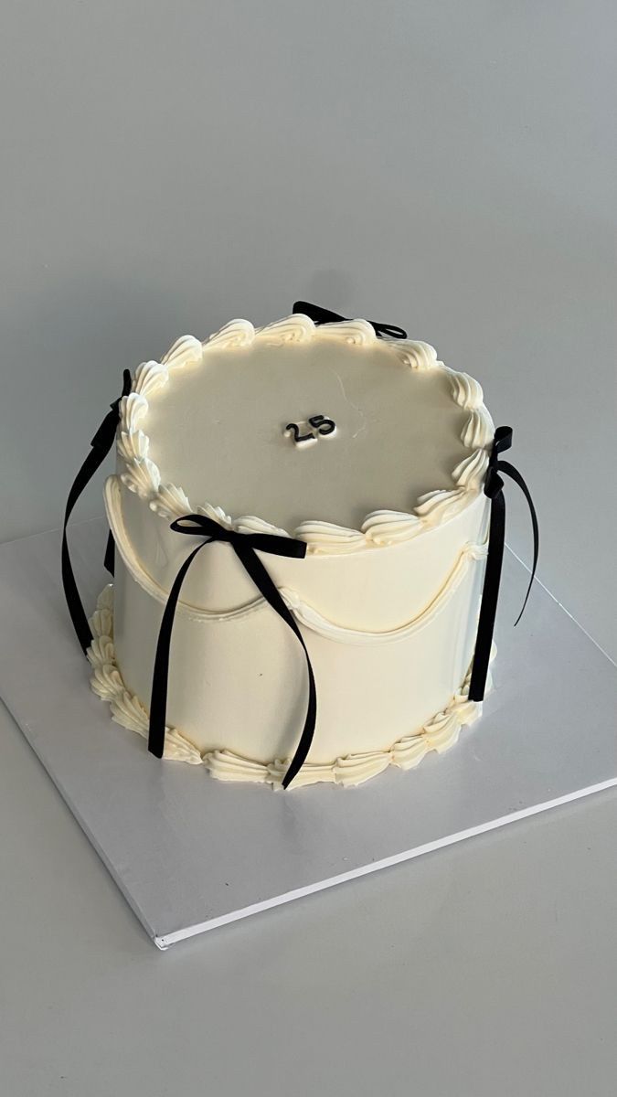 a white cake with black ribbon on top