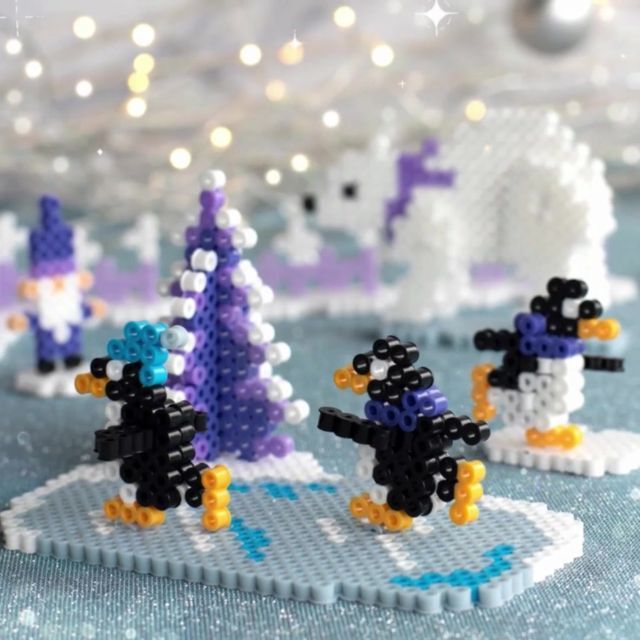 some lego penguins are standing in front of christmas trees and snowflakes on the table