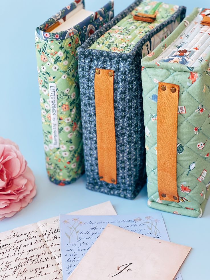 three boxes are lined up next to each other on a blue table with envelopes