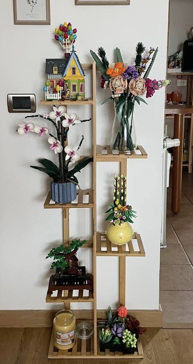 a shelf filled with flowers on top of a wooden floor