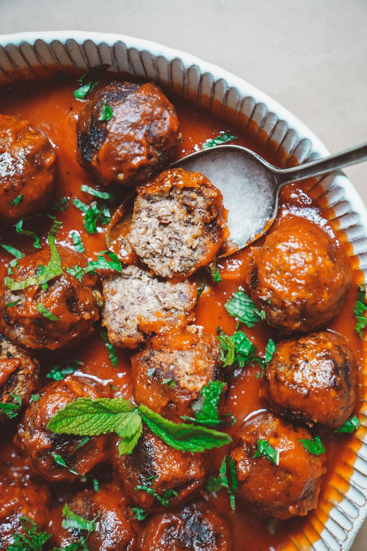 meatballs and sauce in a bowl with a spoon