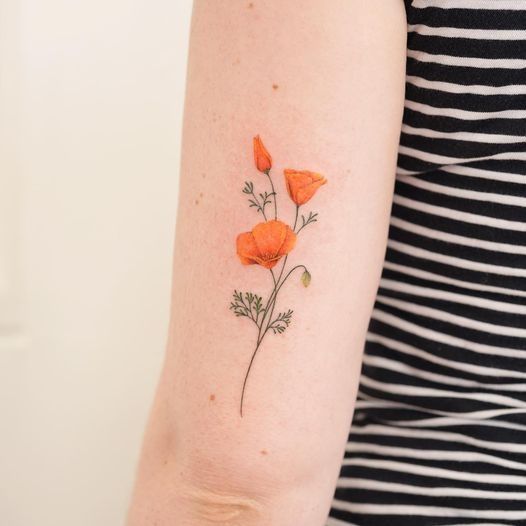 an orange flower tattoo on the arm