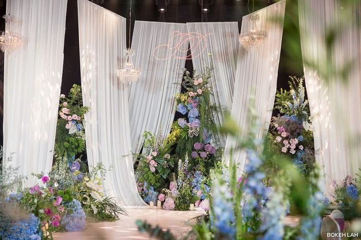 an image of a wedding stage setting with flowers and chandelier hanging from the ceiling