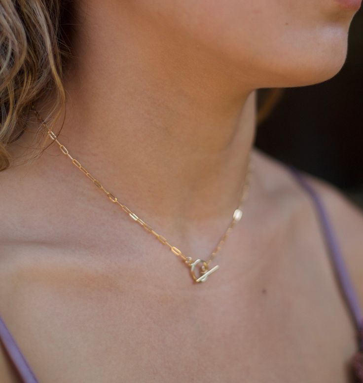 This stylish Toggle Clasp Paperclip Chain Necklace is designed with attention to detail, featuring a intricate toggle clasp connected to a dainty paperclip chain. This necklace is the perfect accessory for any outfit, providing an elegant yet modern touch. Simple yet perfect for every day. High-Quality Solid 14k Gold-Filled 14k gold-filled Hypoallergenic Handmade in California ∙ LENGTH Please choose from the drop-down menu The standard length is 18" Chic Toggle Necklace With Paperclip Chain For Everyday, Chic Everyday Toggle Necklace With Paperclip Chain, Trendy Paperclip Necklace With Lobster Clasp, Gold Toggle Necklace With Paperclip Chain, Chic Jewelry With Toggle Clasp And Link Shape, Chic Gold Toggle Necklace With Paperclip Chain, Gold Chic Toggle Necklace With Paperclip Chain, Chic Jewelry With Toggle Clasp And Chain Link, Chic Chain Link Jewelry With Toggle Clasp