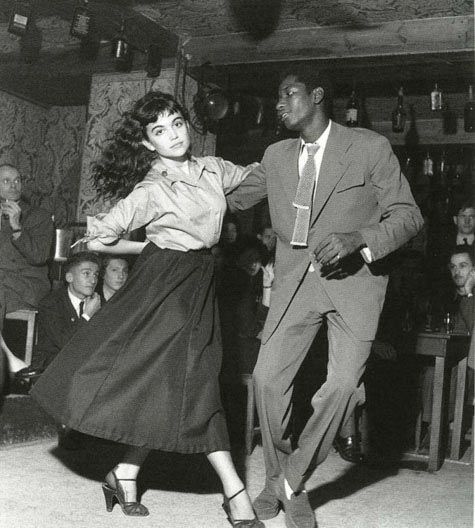 a man and woman dancing in front of an audience