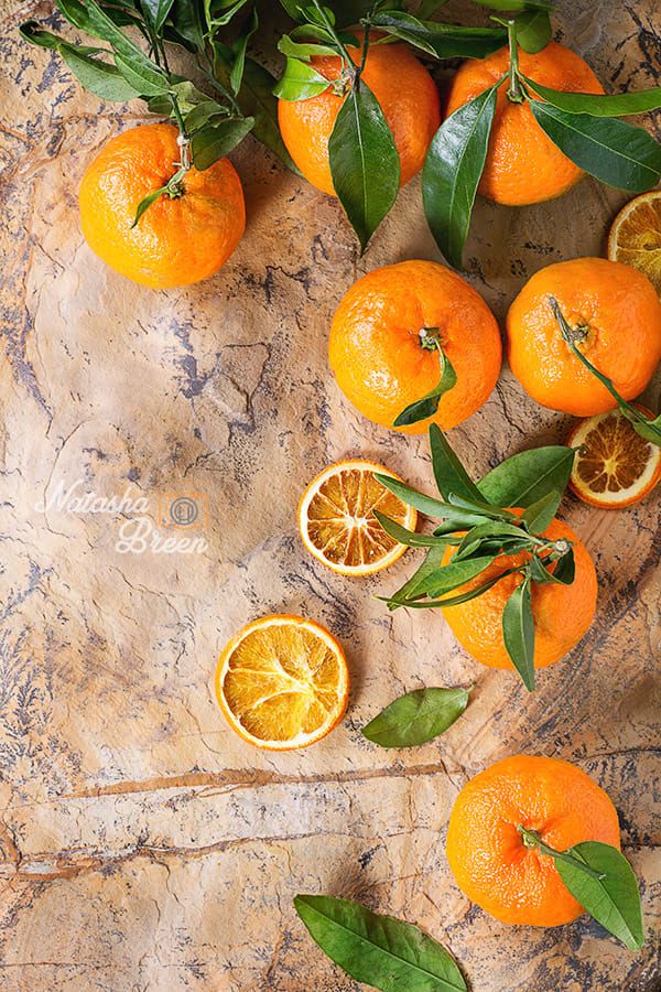 oranges and leaves on a marble surface