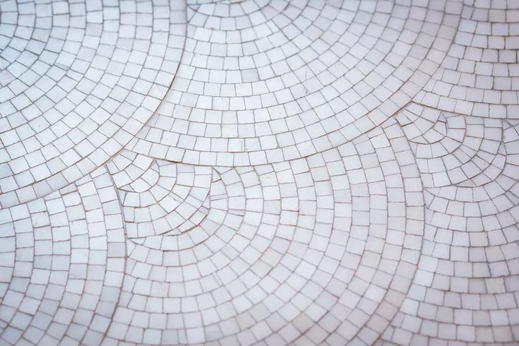 a close up view of a white tile pattern with drops of water on it's surface