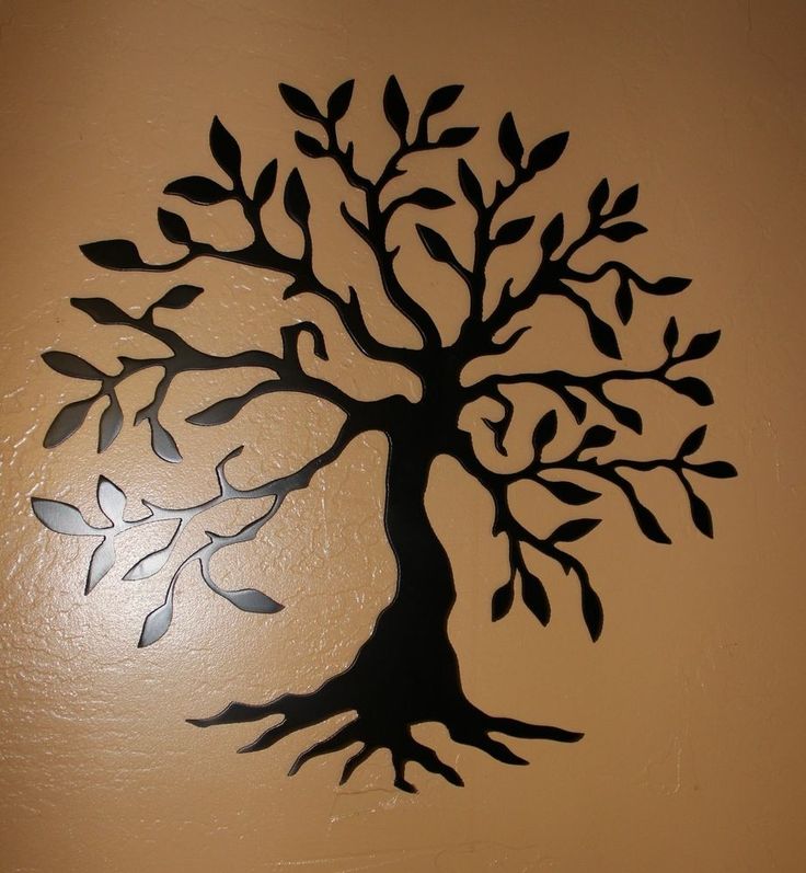 a tree with leaves is cut out on the wall