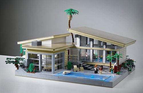 a lego model of a house with a pool and palm tree