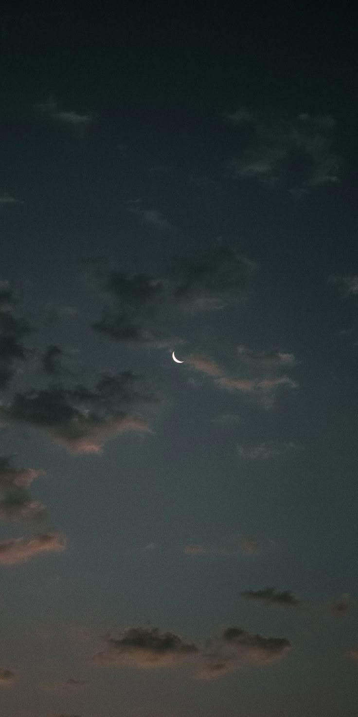 the moon is shining in the sky with clouds